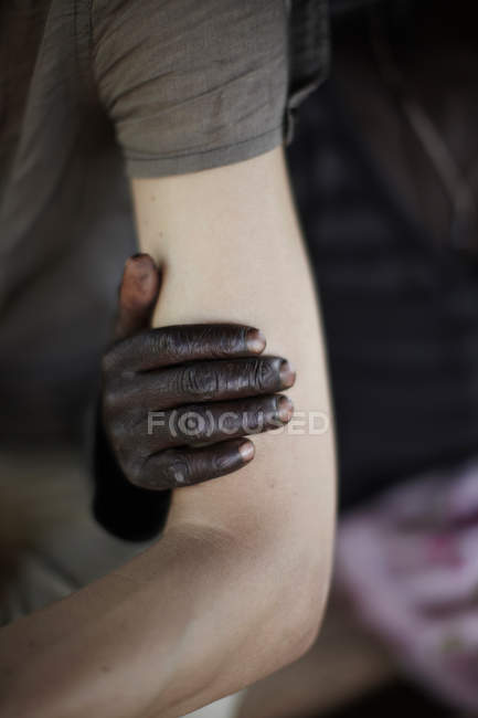 Люди різних етнічних груп, торкаючись — стокове фото
