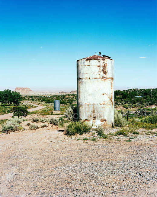 Tanque de água em ambiente rural sob céu azul claro — Fotografia de Stock