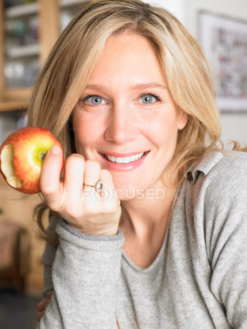 Retrato de una mujer comiendo una manzana - foto de stock
