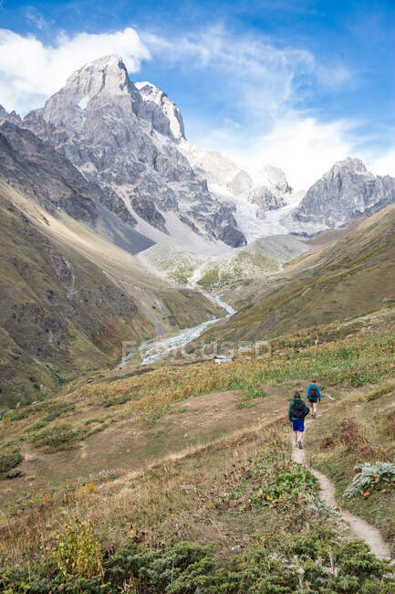 Visão traseira de caminhantes masculinos na paisagem montanhosa, Ushba, Svaneti, Geórgia — Fotografia de Stock