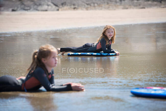 Niños en tablas de surf en agua - foto de stock