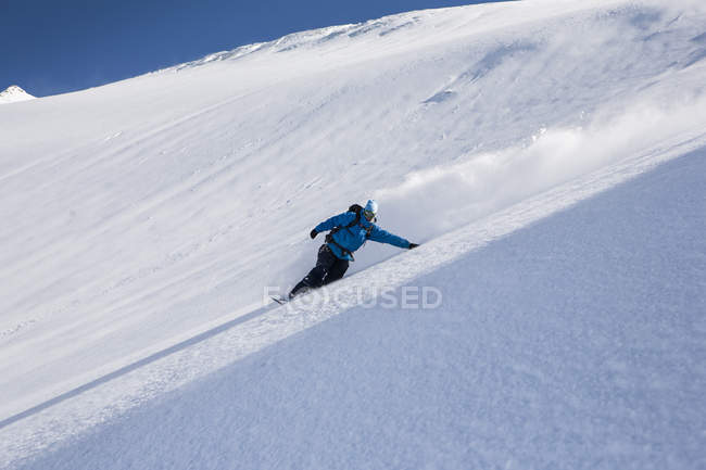 Snowboarder macho snowboard down steep mountain, Trient, Swiss Alps, Suiza - foto de stock