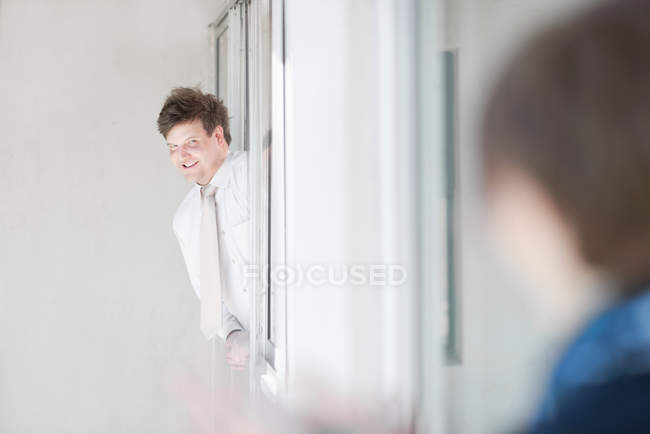 Бизнесмен, высунувшийся из окна, избирательный фокус — стоковое фото