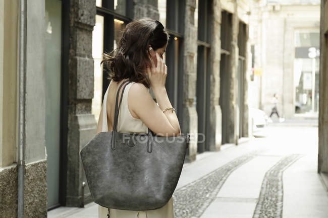 Woman using smartphone on traditional street, Milan, Italy — Stock Photo