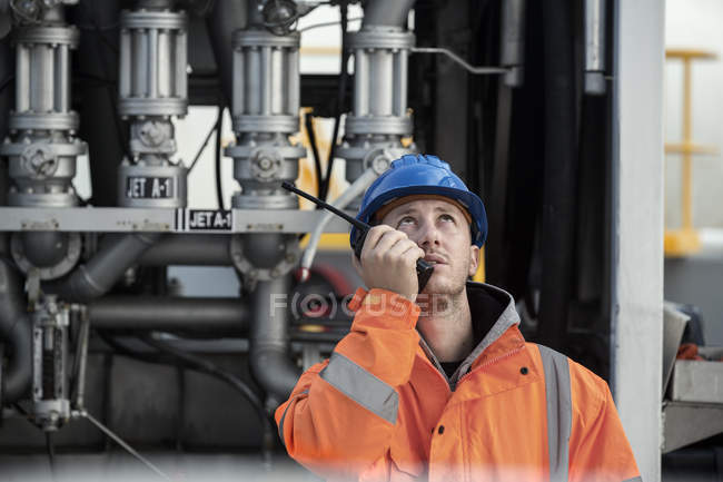Trabalhador do sexo masculino falando em rádio bidirecional no depósito de combustível — Fotografia de Stock