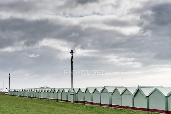 Bath houses under cloudy sky, Brighton beach, England — Stock Photo