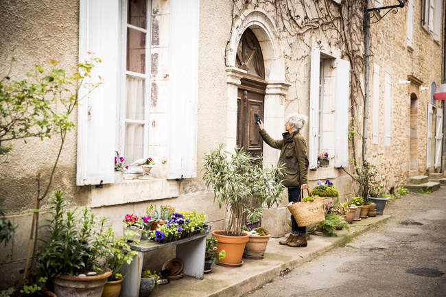 Femme frappant à la porte, Bruniquel, France — Photo de stock