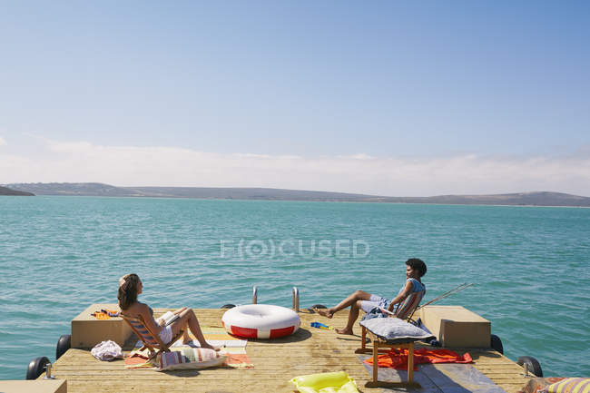 Pareja relajante en la cubierta del sol de la casa flotante, Kraalbaai, Sudáfrica - foto de stock