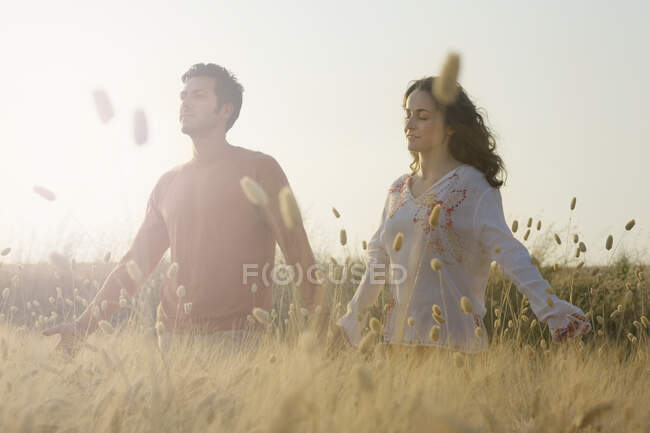 Couple holding hands in wheat field — Stock Photo
