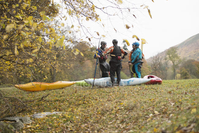 Male and female kayakers having team talk, Llangollen, North Wales — Stock Photo