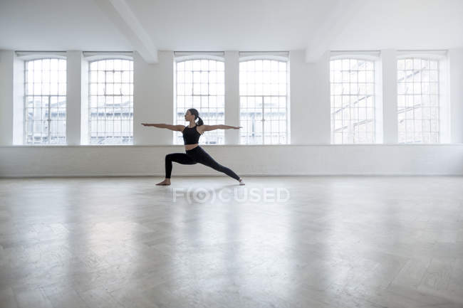 Woman in dance studio in yoga position — Stock Photo