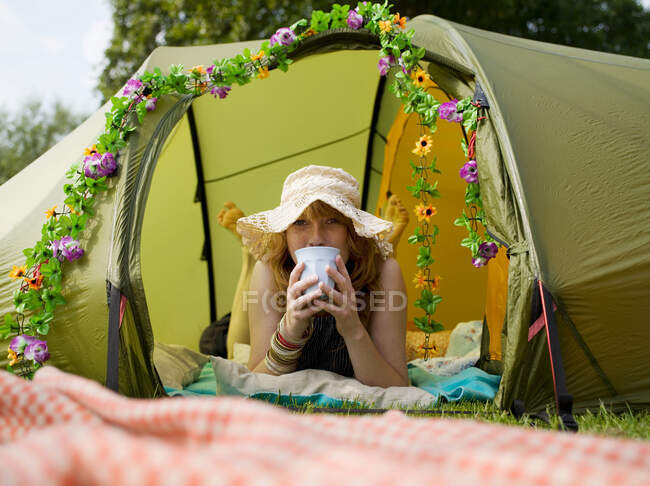 Frau liegt im Zelt und schaut hinaus — Stockfoto
