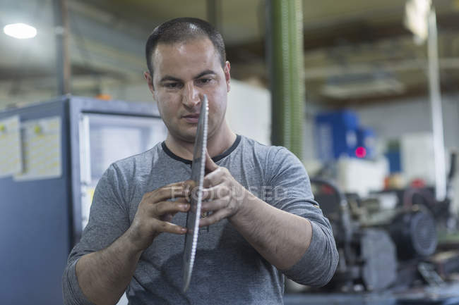 Caucasian adult man checking rotary blade in workshop — Stock Photo