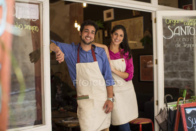 Propietarios de restaurante de pie en la entrada de la cafetería, Palma de Mallorca, España - foto de stock