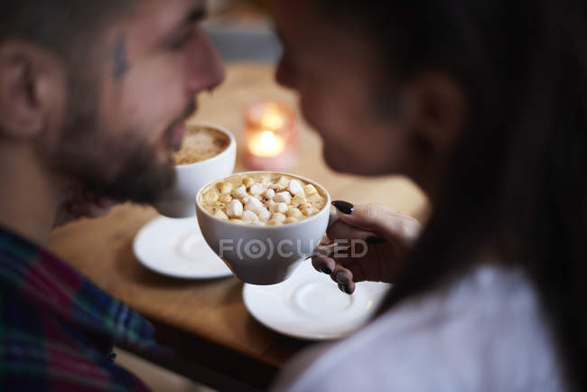 Пара в кав'ярні обличчям до обличчя посміхається — стокове фото