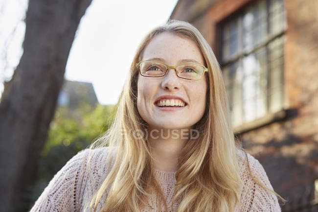 Ritratto di giovane donna all'aperto, capelli lunghi biondi e occhiali — Foto stock
