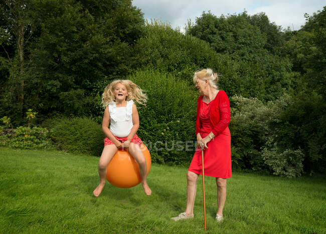 Older woman and granddaughter in meadow — Stock Photo