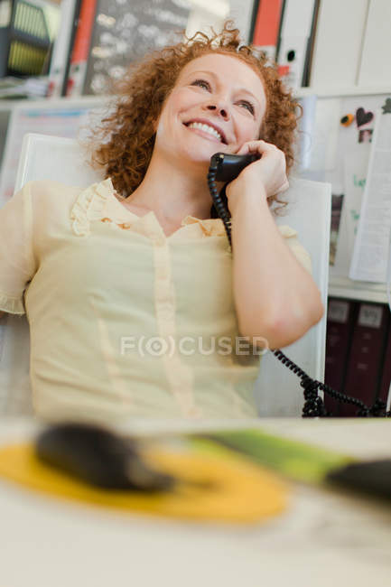 Donna d'affari che parla al telefono alla scrivania — Foto stock