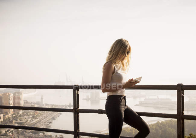 Женщина читает книгу с видом на город, Малага, Испания — стоковое фото