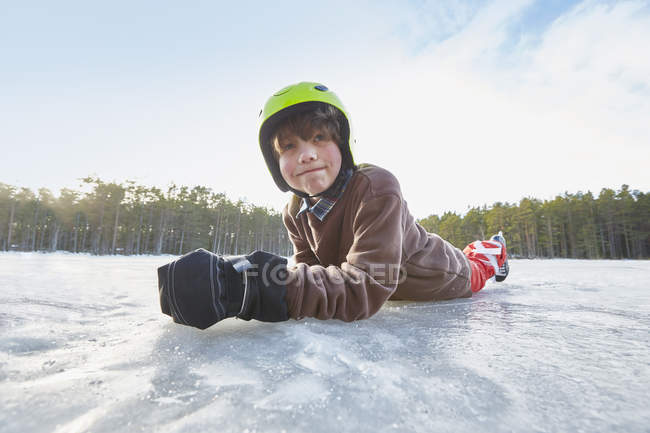 Портрет хлопчик, лежачи на своєму фронті на замерзлому озері, Gavle, Швеція — стокове фото