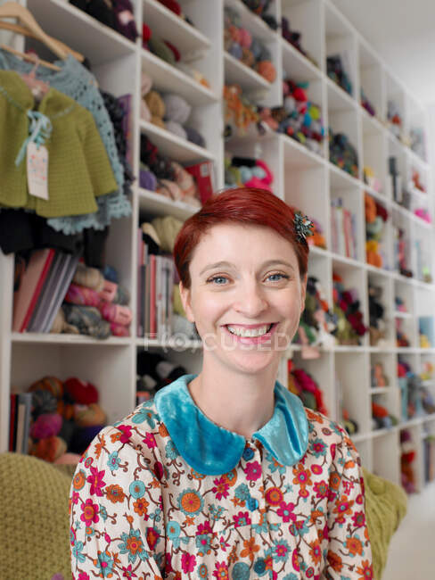 Mujer sentada en tienda de artesanía sonriendo - foto de stock
