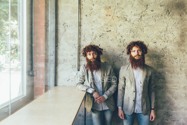 Ritratto di gemelli hipster maschi identici in carica — Foto stock