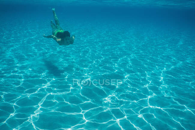 Vista submarina de la mujer nadando en el mar - foto de stock