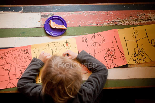 Молодий хлопчик малює за столом — стокове фото