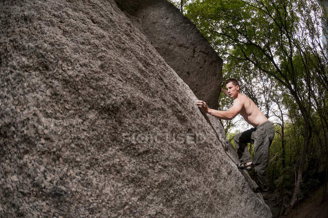 Rock climber scaling boulder — Stock Photo