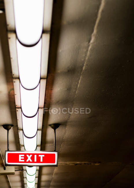 Sinal de saída e luzes fluorescentes no teto — Fotografia de Stock