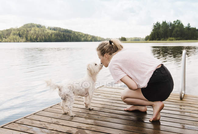 Frau küsst coton de tulear Hund auf Pier, orivesi, Finnland — Stockfoto