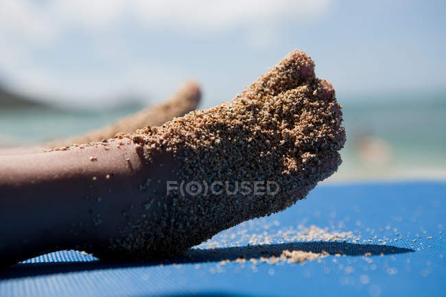 Criança pés cobertos de areia molhada, close-up tiro — Fotografia de Stock
