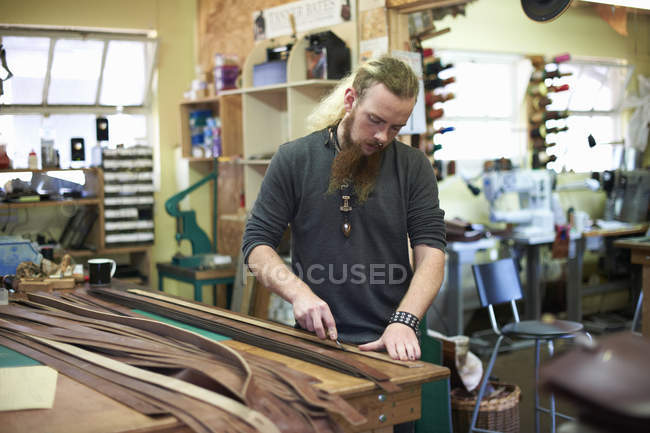 Trabalhador masculino na oficina de couro, medindo couro — Fotografia de Stock