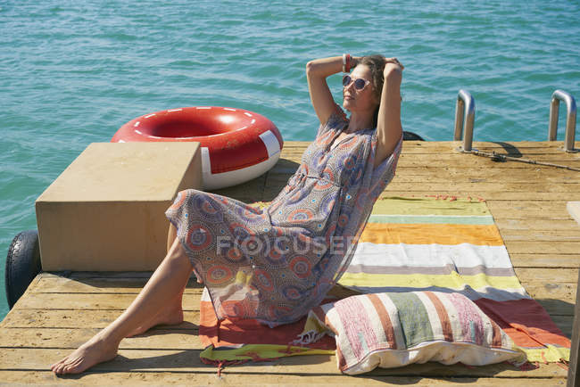 Donna che prende il sole sul ponte prendisole houseboat, Kraalbaai, Sud Africa — Foto stock
