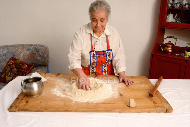 Donna anziana che cucina in soggiorno — Foto stock