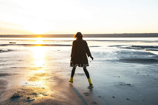 Жінка насолоджується пляжем на заході сонця — стокове фото