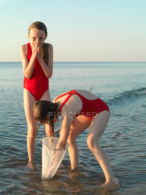 Girls fishing in shallow water — Stock Photo