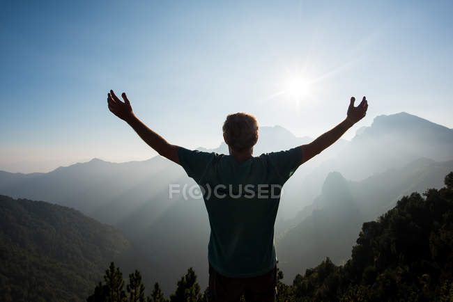 Rear view of man, arms raised looking at view of mountains, Passo Maniva, Italy — Stock Photo