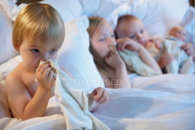 Bebês na cama com seus cobertores — Fotografia de Stock