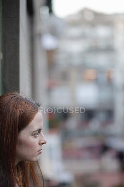 Mujer junto a la ventana - foto de stock