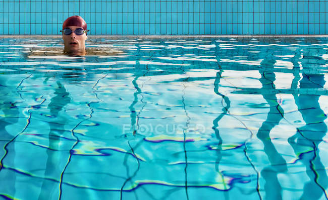 Uomo nuoto in piscina coperta — Foto stock