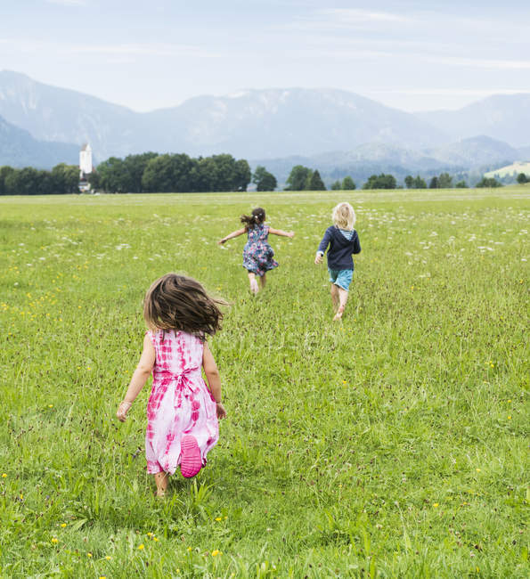 Vue arrière des enfants qui courent sur le terrain, Fuessen, Bavière, Allemagne — Photo de stock