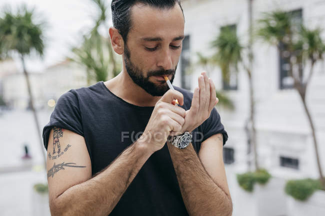 Homem adulto médio acendendo cigarro — Fotografia de Stock