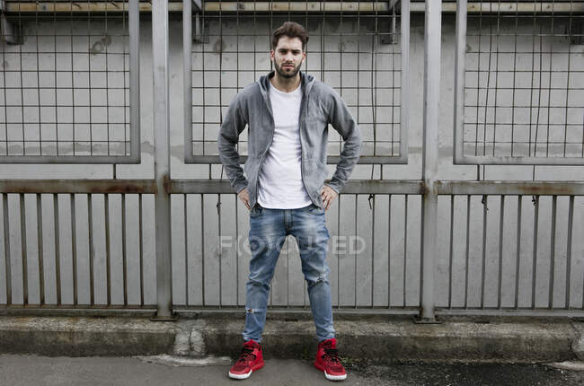 Portrait of young man, wearing hooded top, hands on hips — Stock Photo
