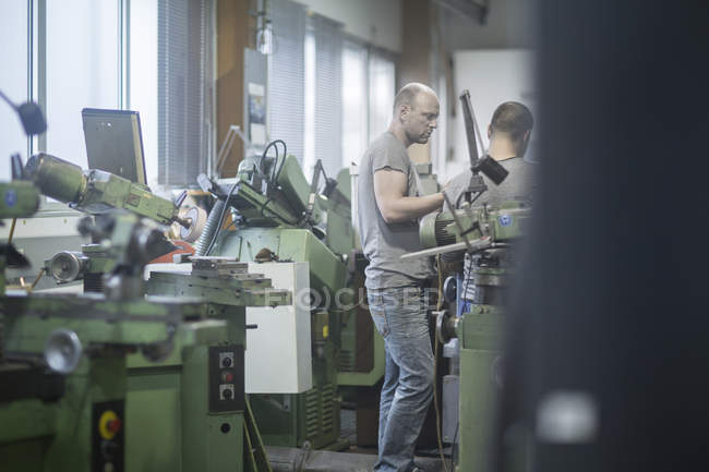 Caucasian adult men working in grinding workshop — Stock Photo