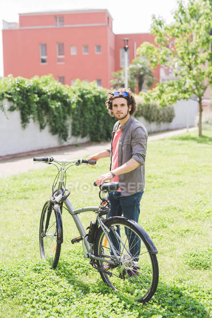 Happy caucasian Man with bicycle in park — Stock Photo