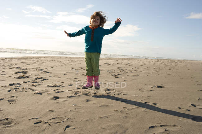 Молода дівчина стрибає на піщаному пляжі — стокове фото