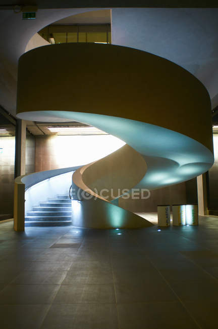 Современная винтовая лестница освещена снизу, вид изнутри — стоковое фото