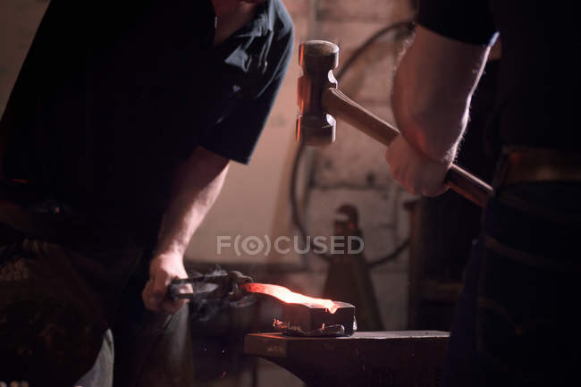 Farriers forging horseshoe on anvil — Stock Photo