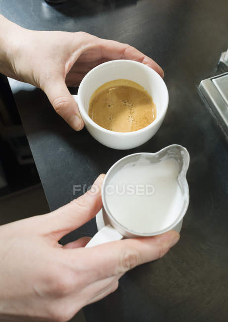 Mani di cameriera preparare cappuccino in caffè — Foto stock